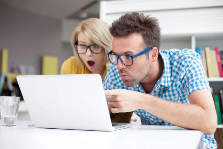 Two surprised students learning in library